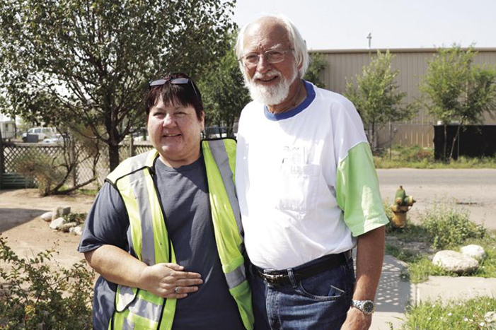 Homeowner Ancilla Quintana, left, stands next to Jerry Saxton, volunteer and board member for Rebuilding Together at Southern Sandoval County. Saxton helped install the new swamp cooler on Quintana’s roof.