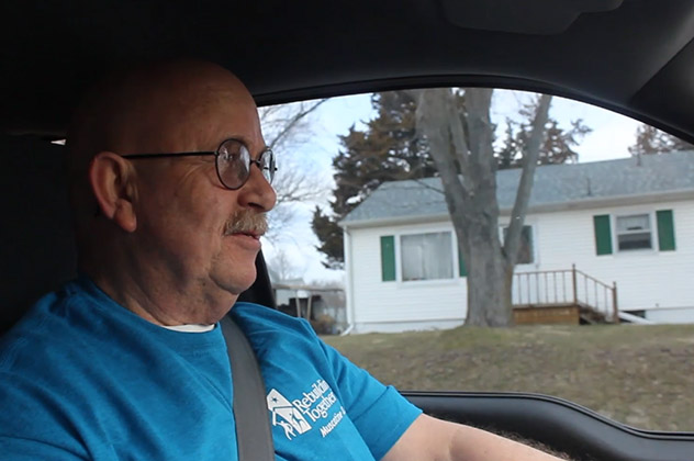 Frank in a Rebuilding Together tshirt driving through Muscatine County